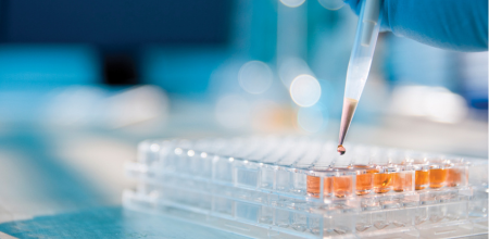 "Researcher Researcher dropping liquid from a dropper into small containers.
