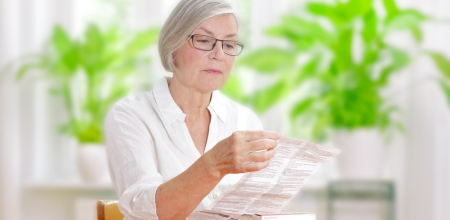 "A A female patient reads a package leaflet for a medicine.